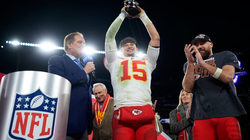 Kansas City Chiefs quarterback Patrick Mahomes (15) holds up the Lamar Hunt Trophy next to...